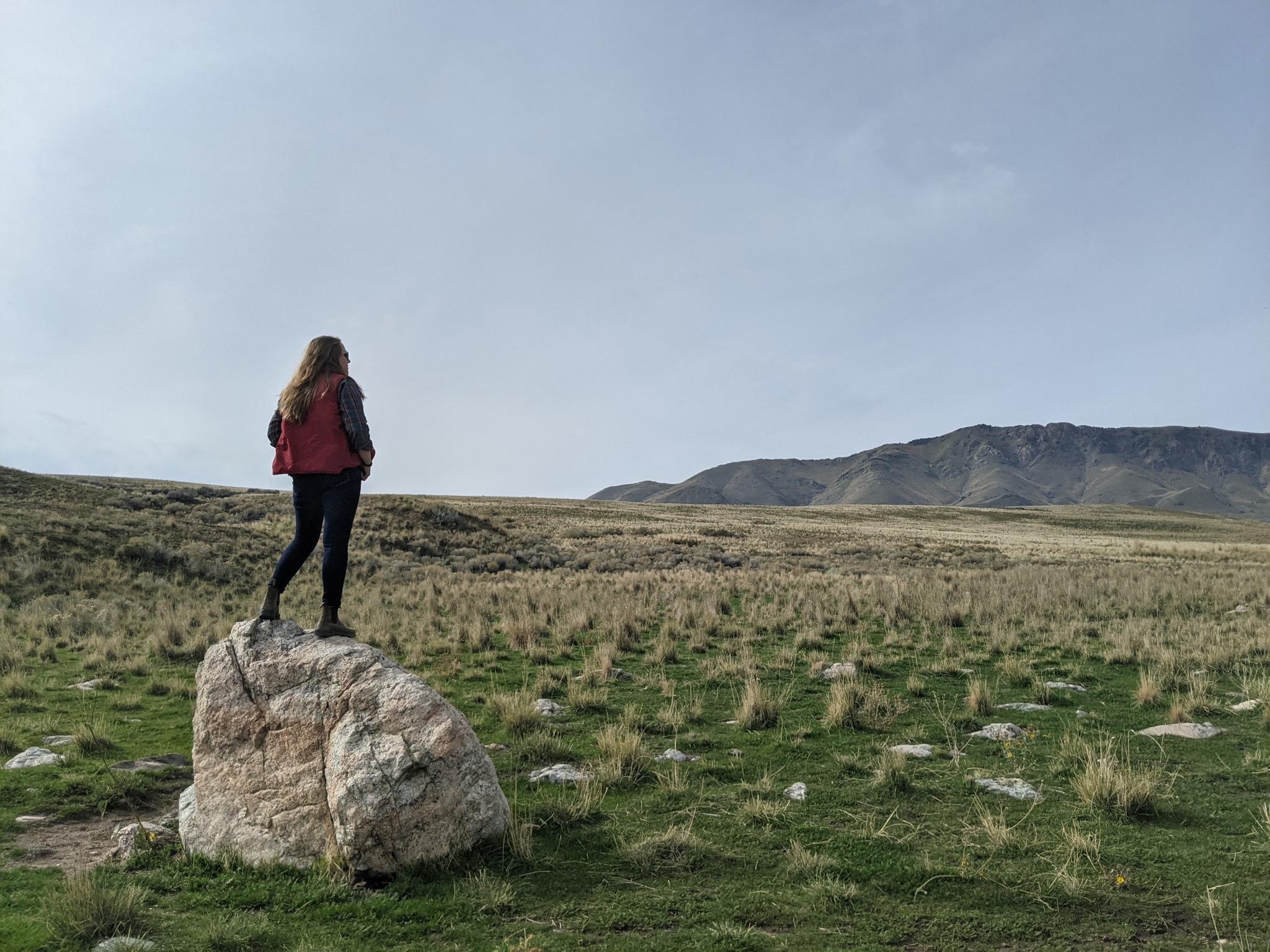 Amelia standing on a rock on Antelope Island, looking for Buffalo